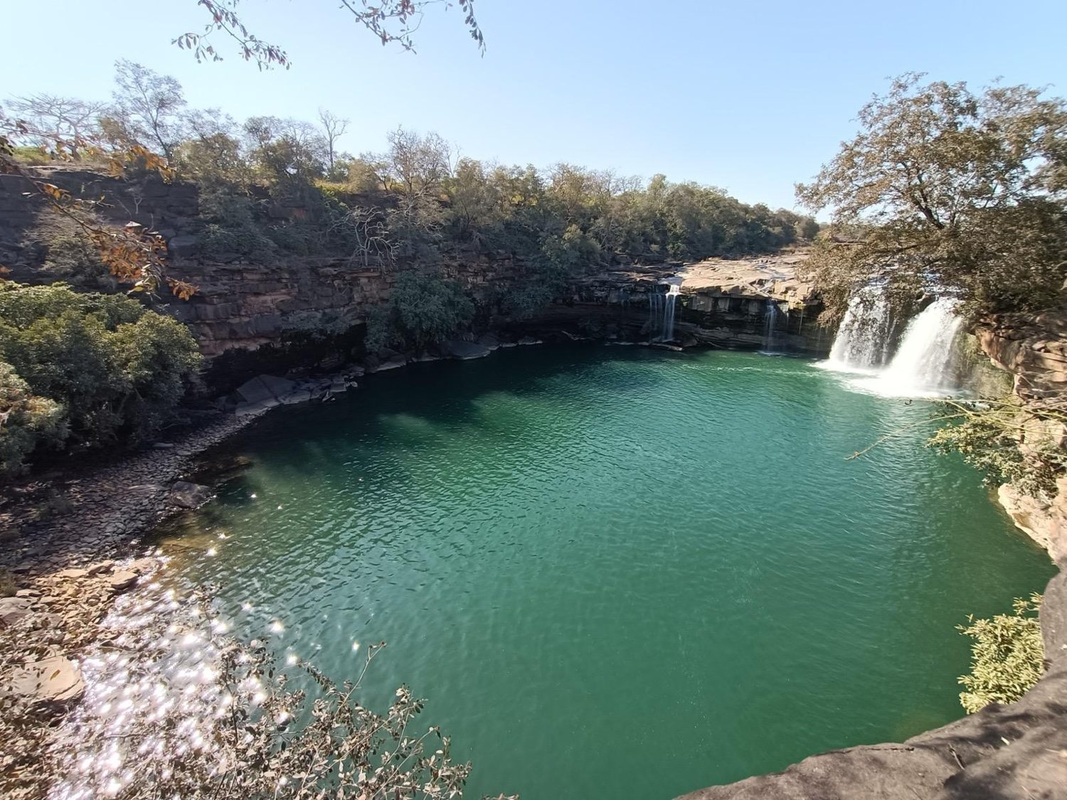 Hidden waterfall and green pool in the forest