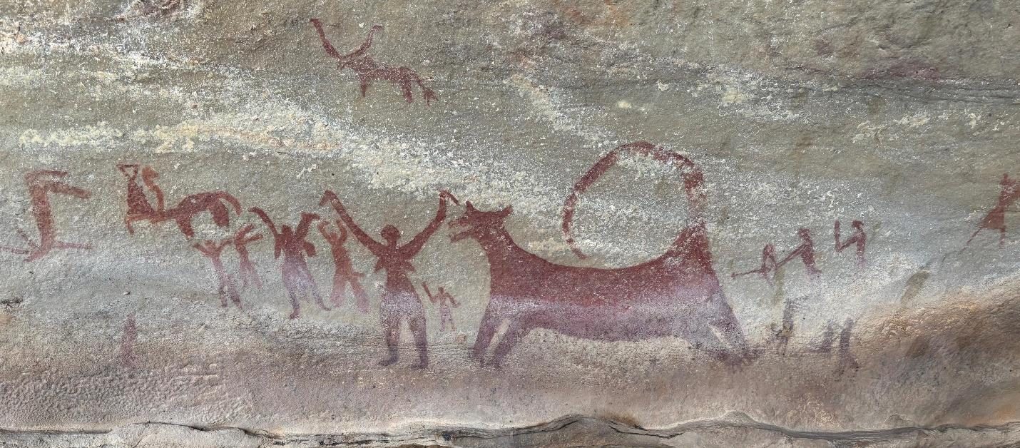 Ancient red rock painting of human figures and an animal
