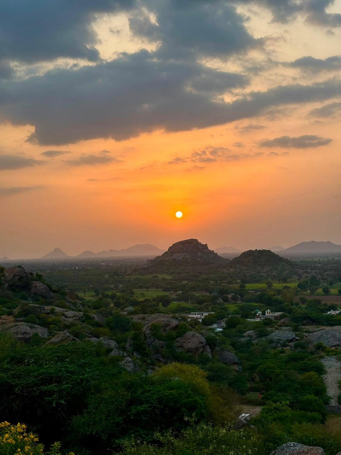 Sunset over granite hills and green farmland near Ranakpur